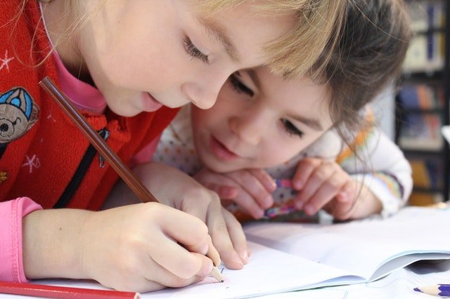 Duas crianças escrevendo