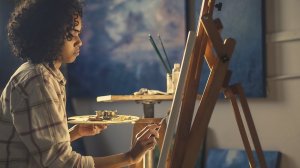 Mulher sentada num ateliê pintando
