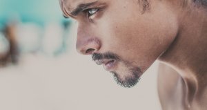 Homem com cara séria olhando para o lado