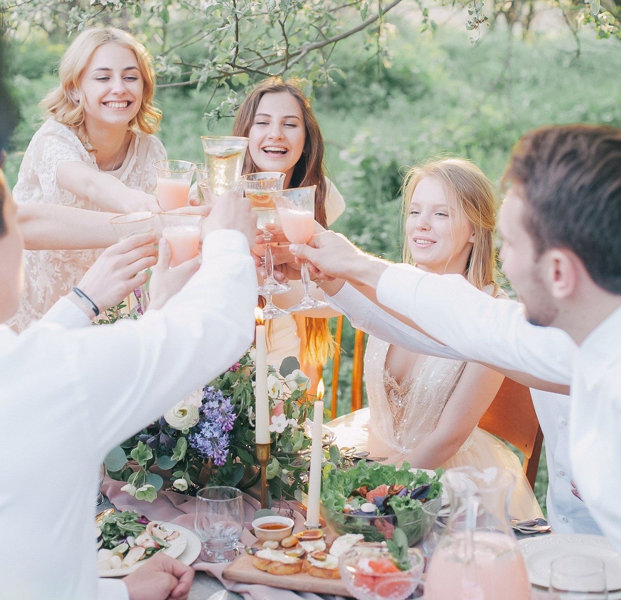 Família de cinco pessoas brindando numa festa ao ar livre