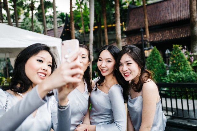 Quatro amigas tirando selfie numa festa durante o dia