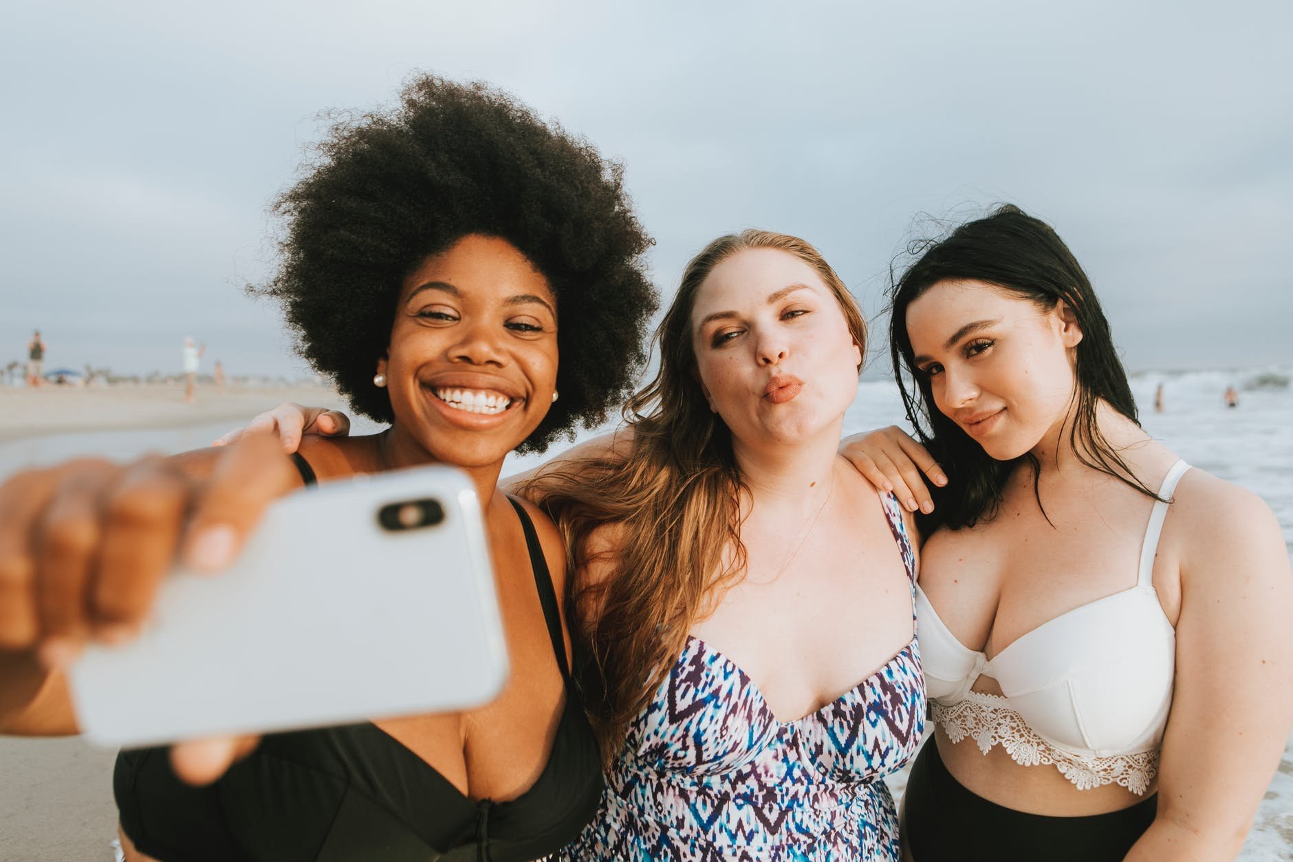 Três amigas tirando selfie na praia