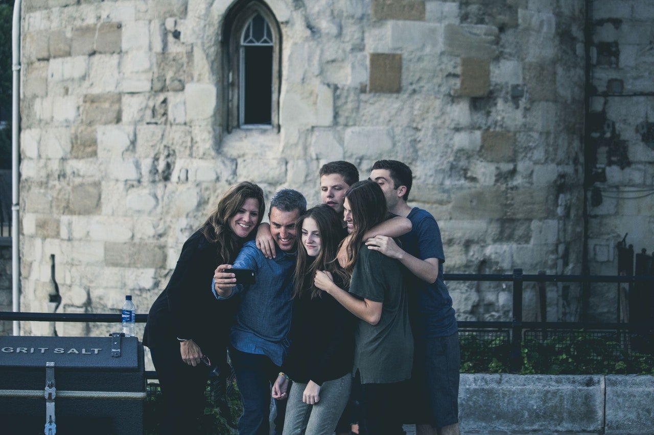 Seis amigos tirando selfie em frente a prédio antigo