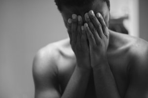 Pessoa chorando com as mãos sobre o rosto.