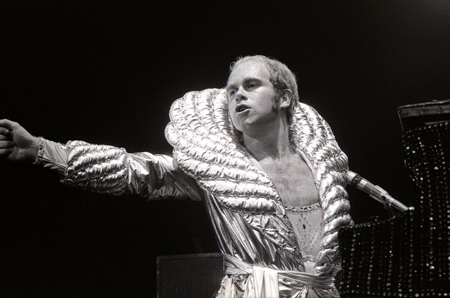 Elton John novo em show usando um roupão branco com gola exagerada