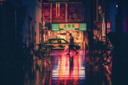 Pessoa caminhando em uma rua à noite.