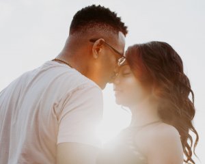 Casal abraçado contra a luz do sol