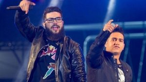 Henrique e Juliano com microfones erguidos