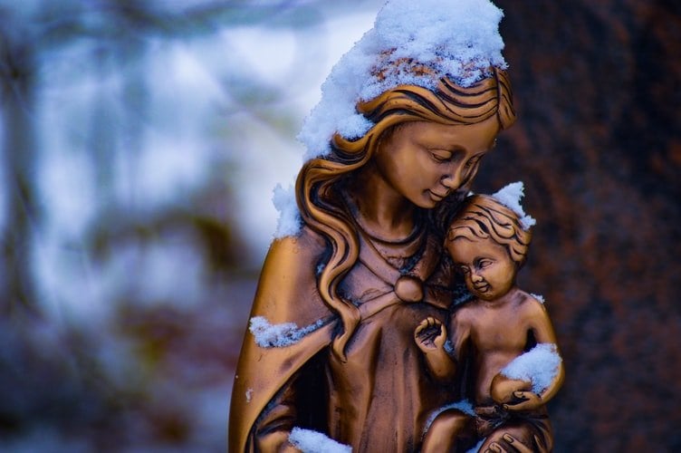 Estátua de bronze de Nossa Senhora segurando um bebê no colo.