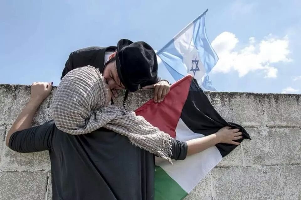 Mulher árabe palestina beija homem judeu israelense por cima da muralha.