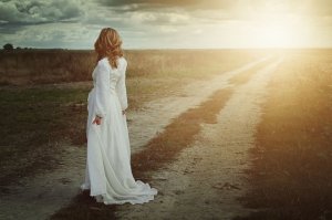 Mulher com vestido longo em estrada