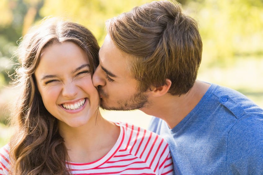 Homem beijando mulher sorridente