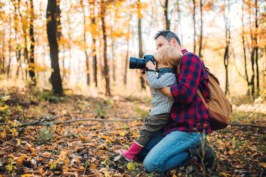 Pai e filho tirando foto na natureza