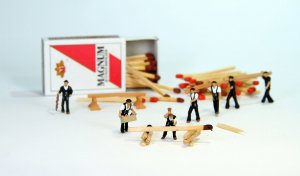 Bonecos de trabalhadores construindo uma caixa de fósforo.