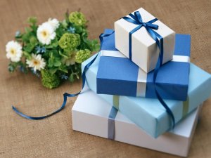 Caixas de presente azuis com flores ao lado.