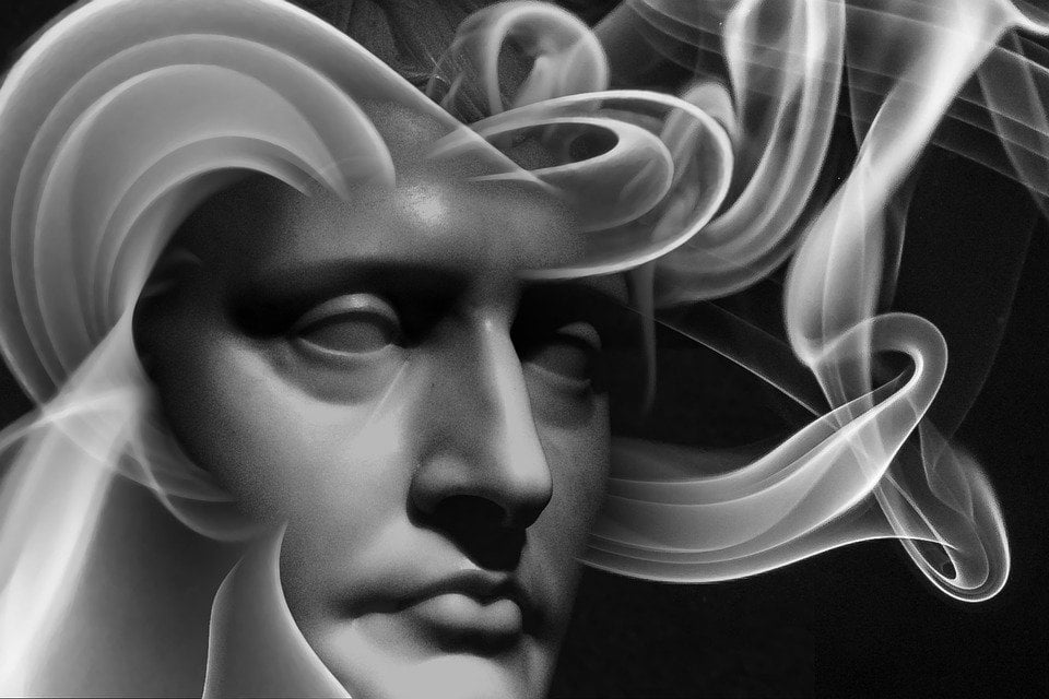 Um rosto de escultura, com fumaça saindo dele.