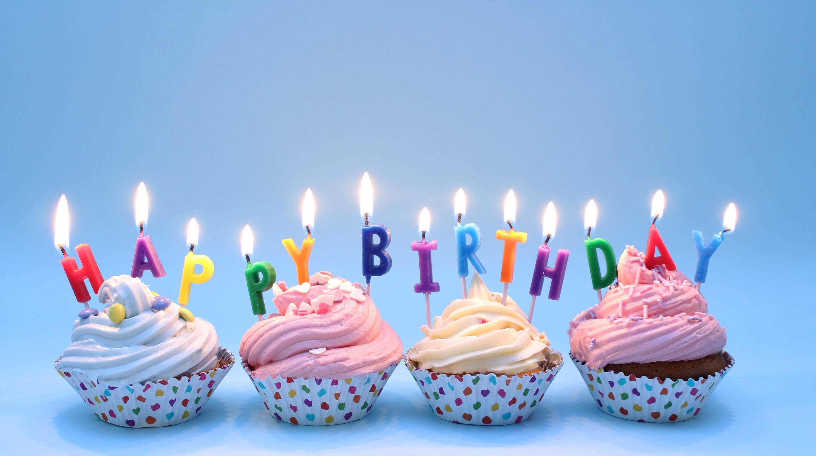 Cupcakes com velas 'happy birthday'.