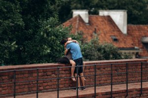 Casal abraçado sentado em cima de mureta