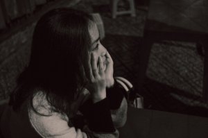Mulher triste sentada com mãos apoiadas no rosto