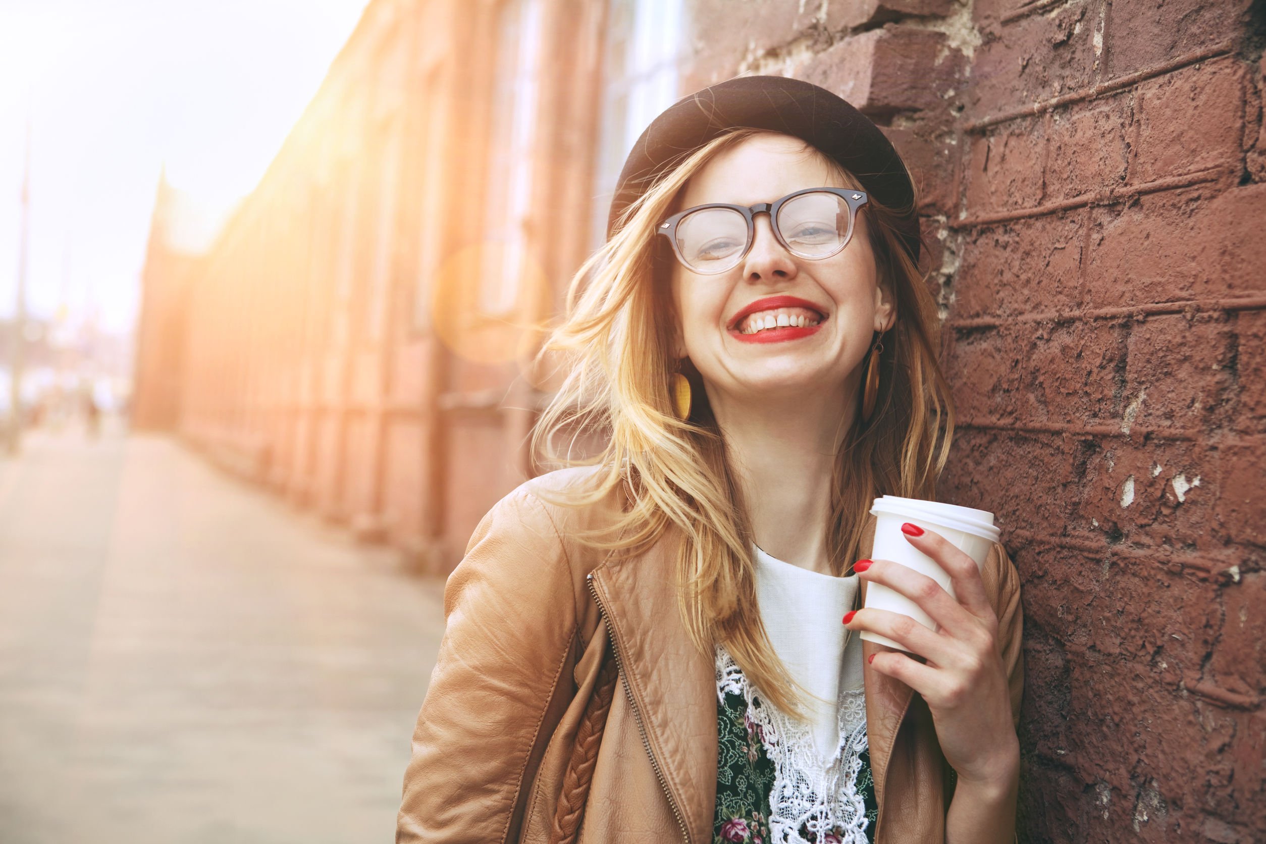 Mulher sorridente segurando copo de café.