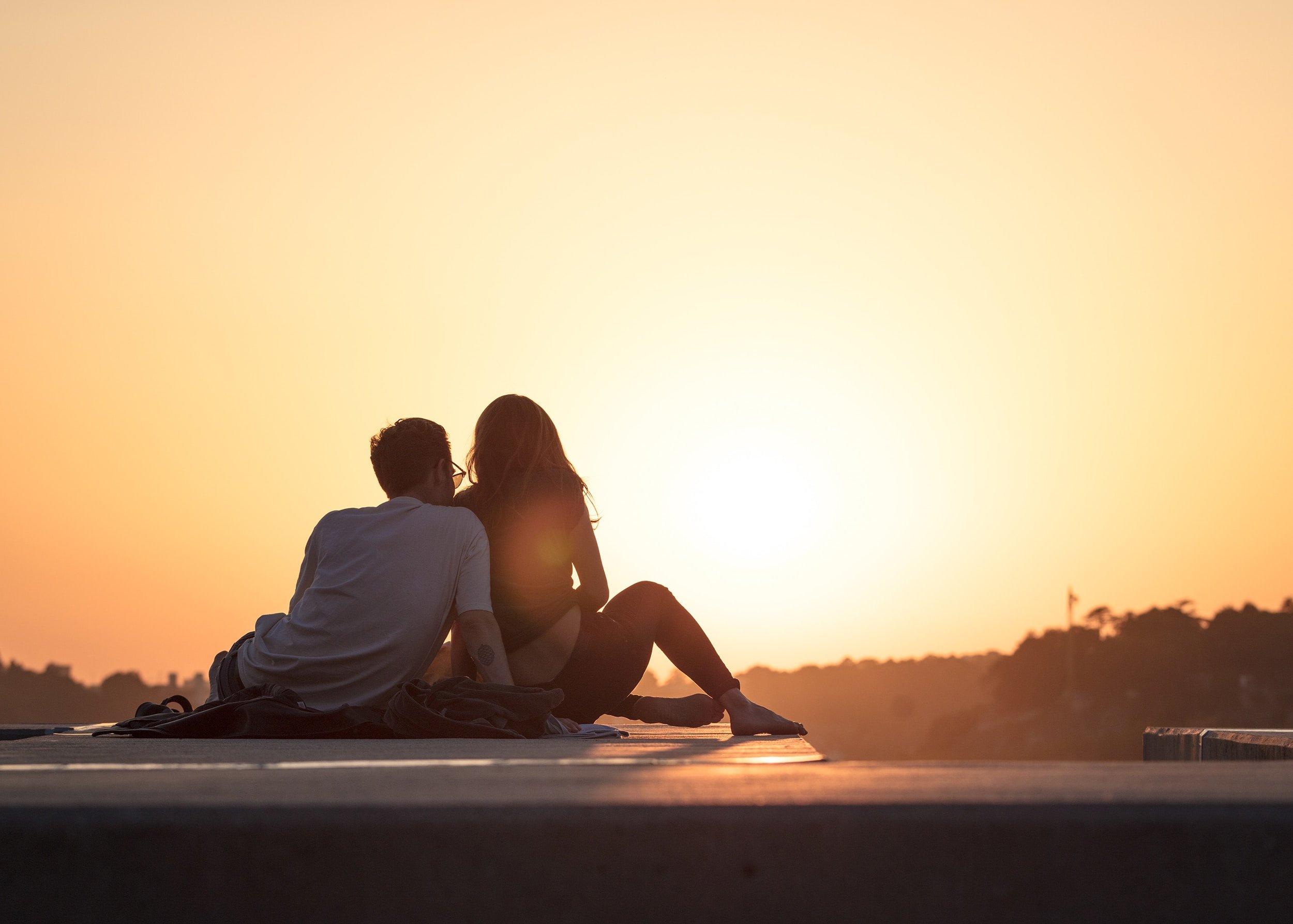 Silhueta de um casal olhando o sol