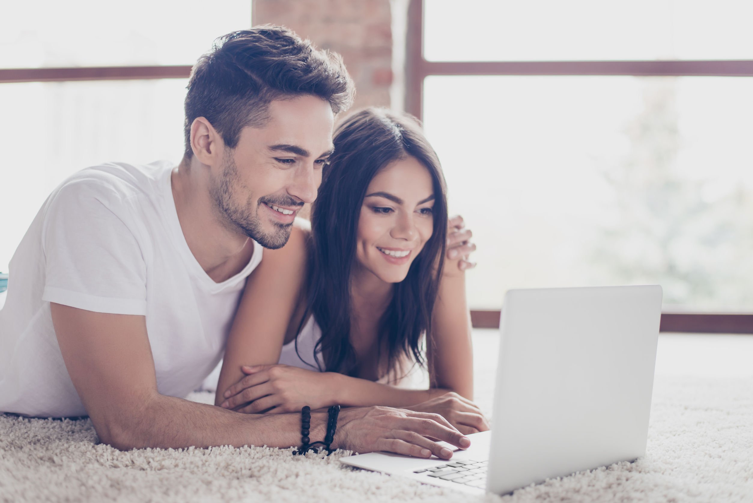 Foto de casal mexendo em computador