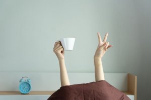 Mão humana segurando xícara de café para cima.