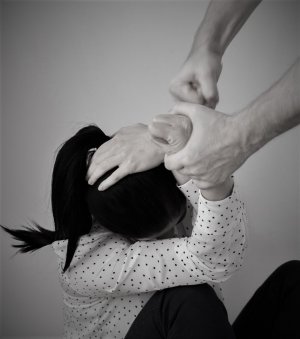Homem segurando mulher e a agredindo