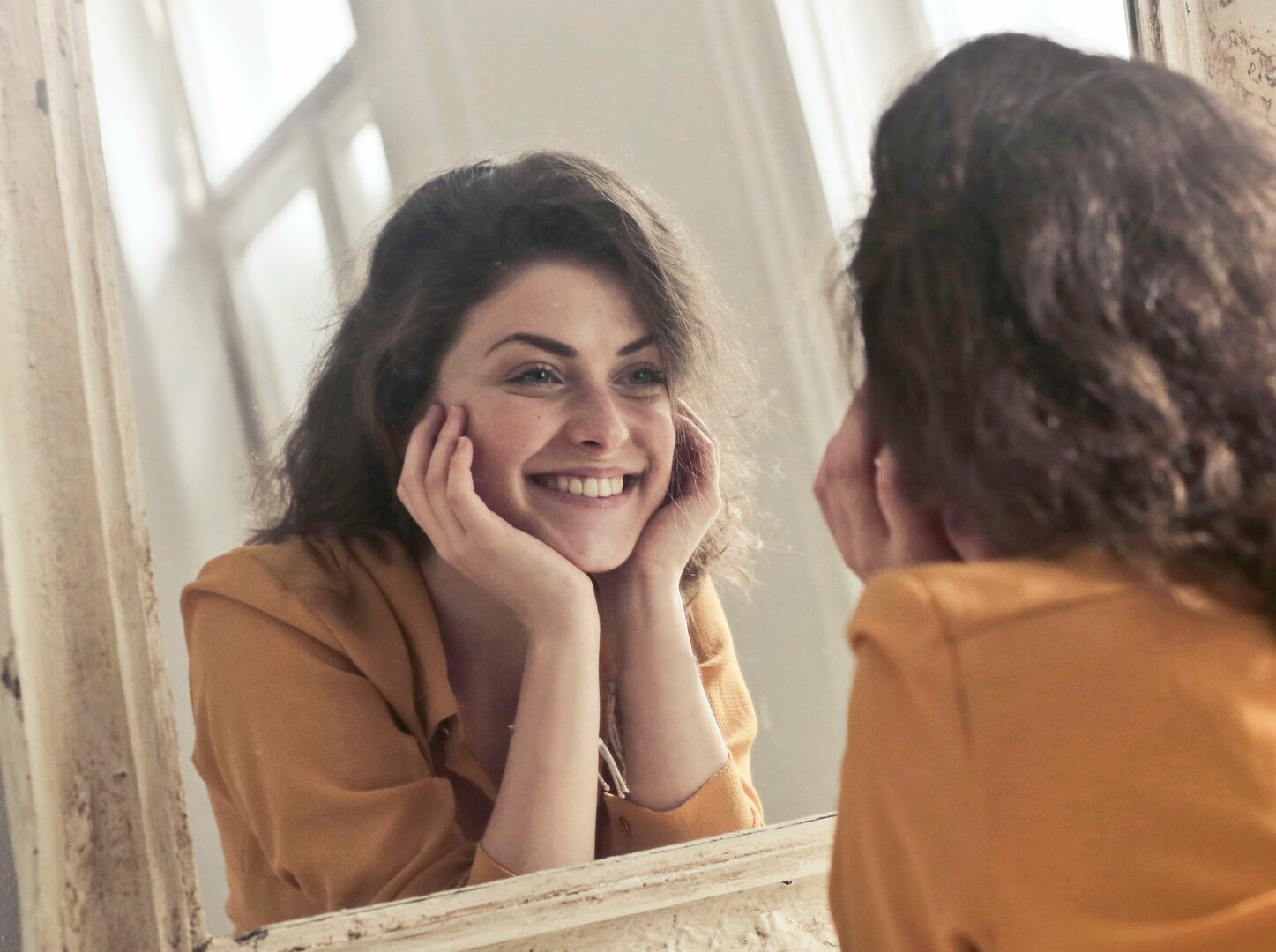 Mulher olhando para o espelho sorrindo