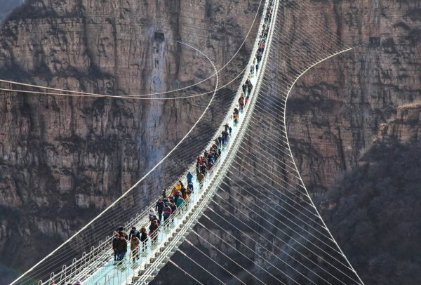 Imagem da ponte de vidro com pessoas caminhando