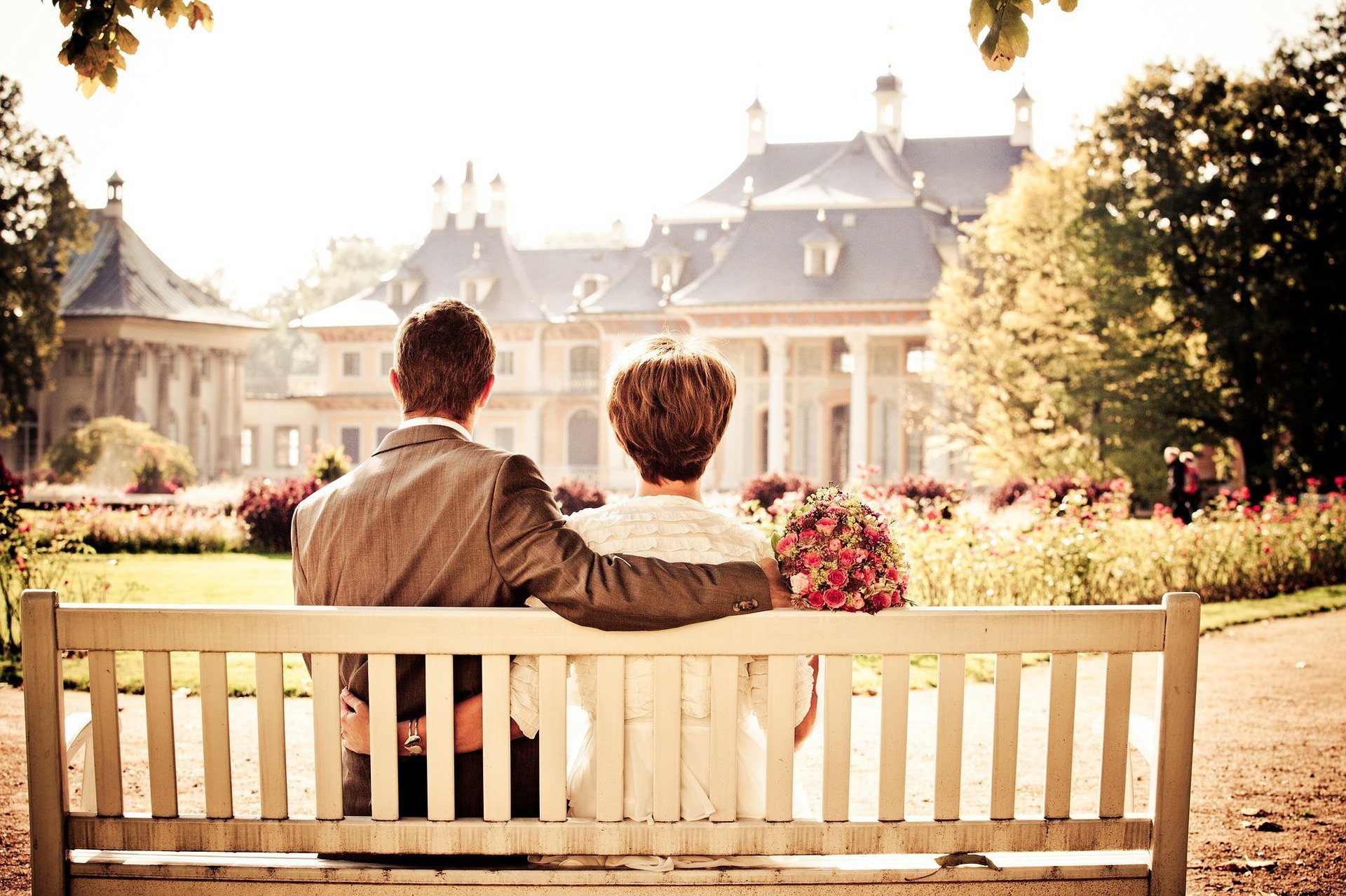 casal sentado no banco de madeira
