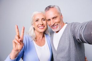 Homem e mulher abraçados sorrindo para foto