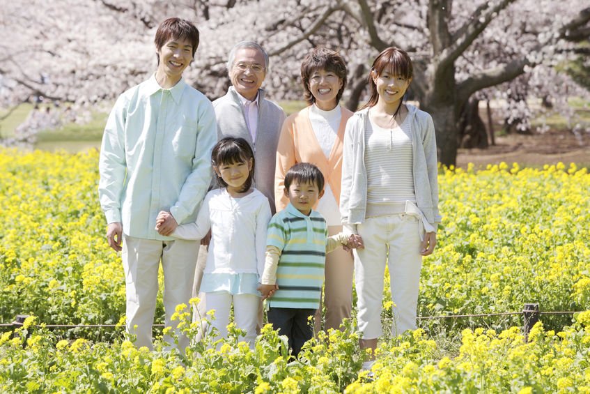 Família asiática em campo de flores