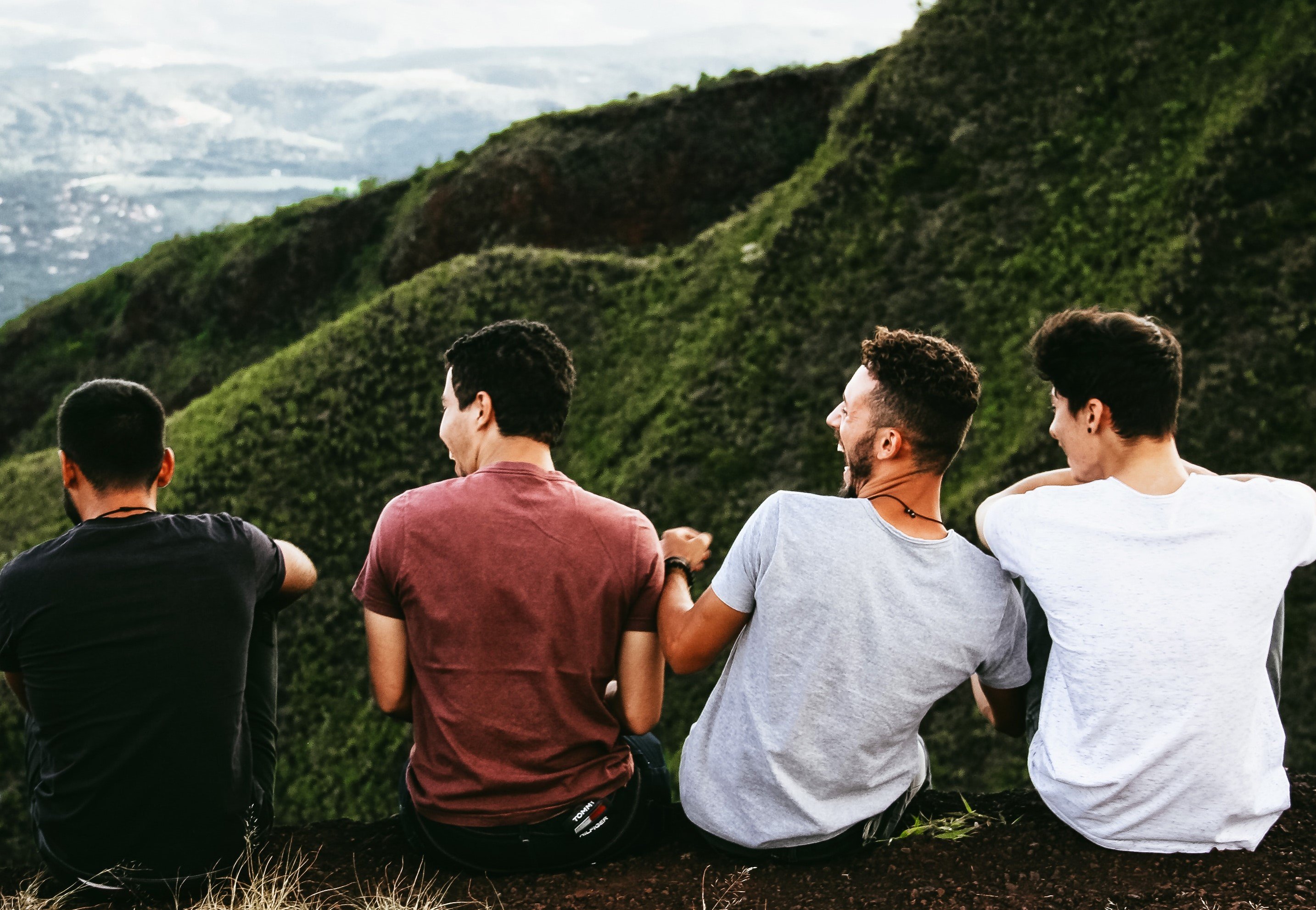 Quatro homens sentados na montanha conversando