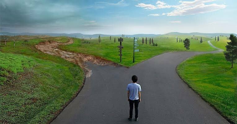 Imagem de homem parado em frente a dois caminhos