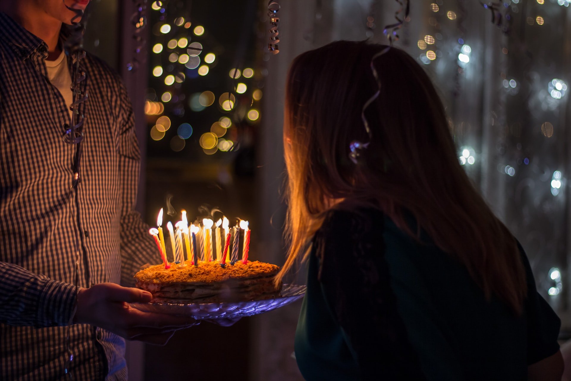Mulher assoprando velas de aniversário.