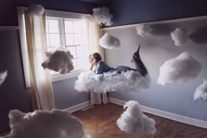 Imagem de mulher deitada em uma nuvem.