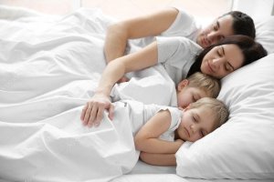 Família dormindo na mesma cama