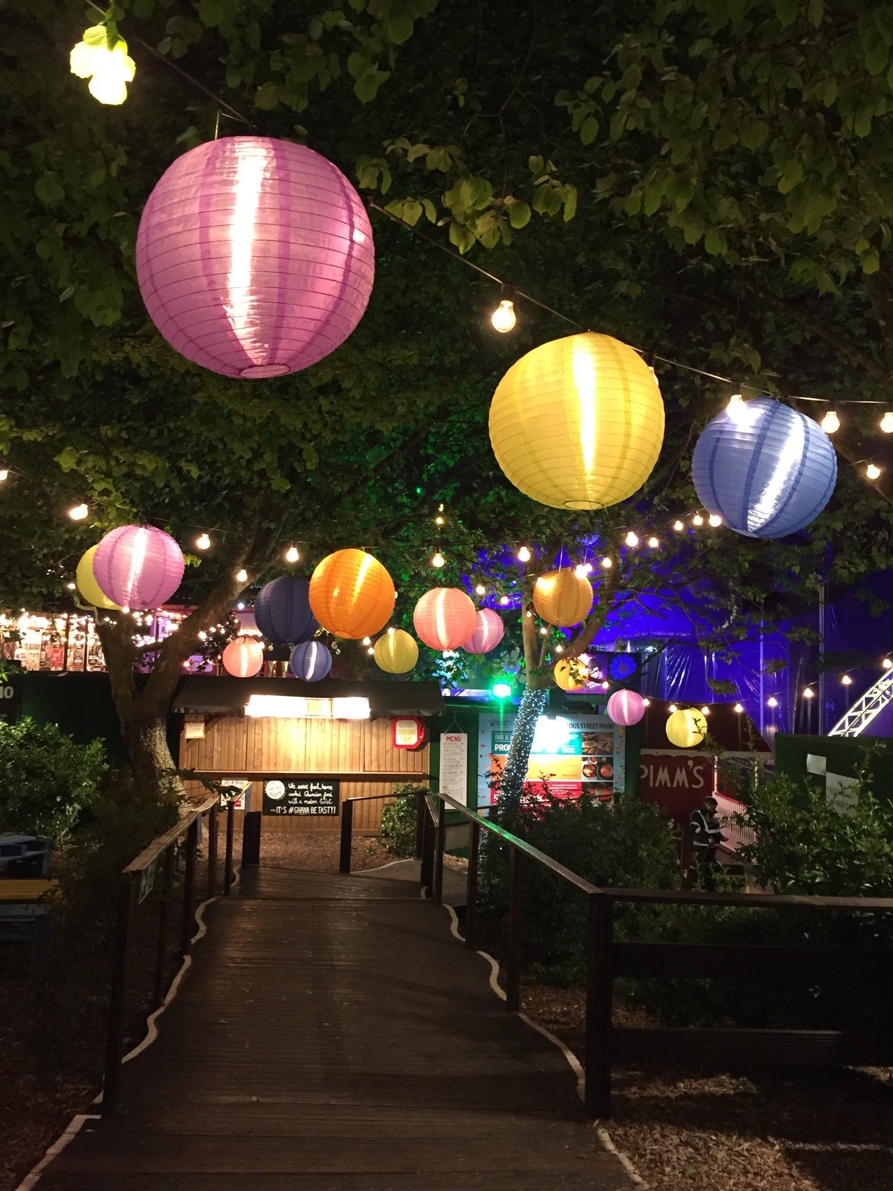 Festa noturna na rua com lanternas coloridas.
