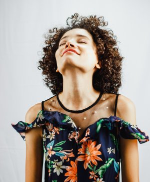Mulher sorrindo com olhos fechados