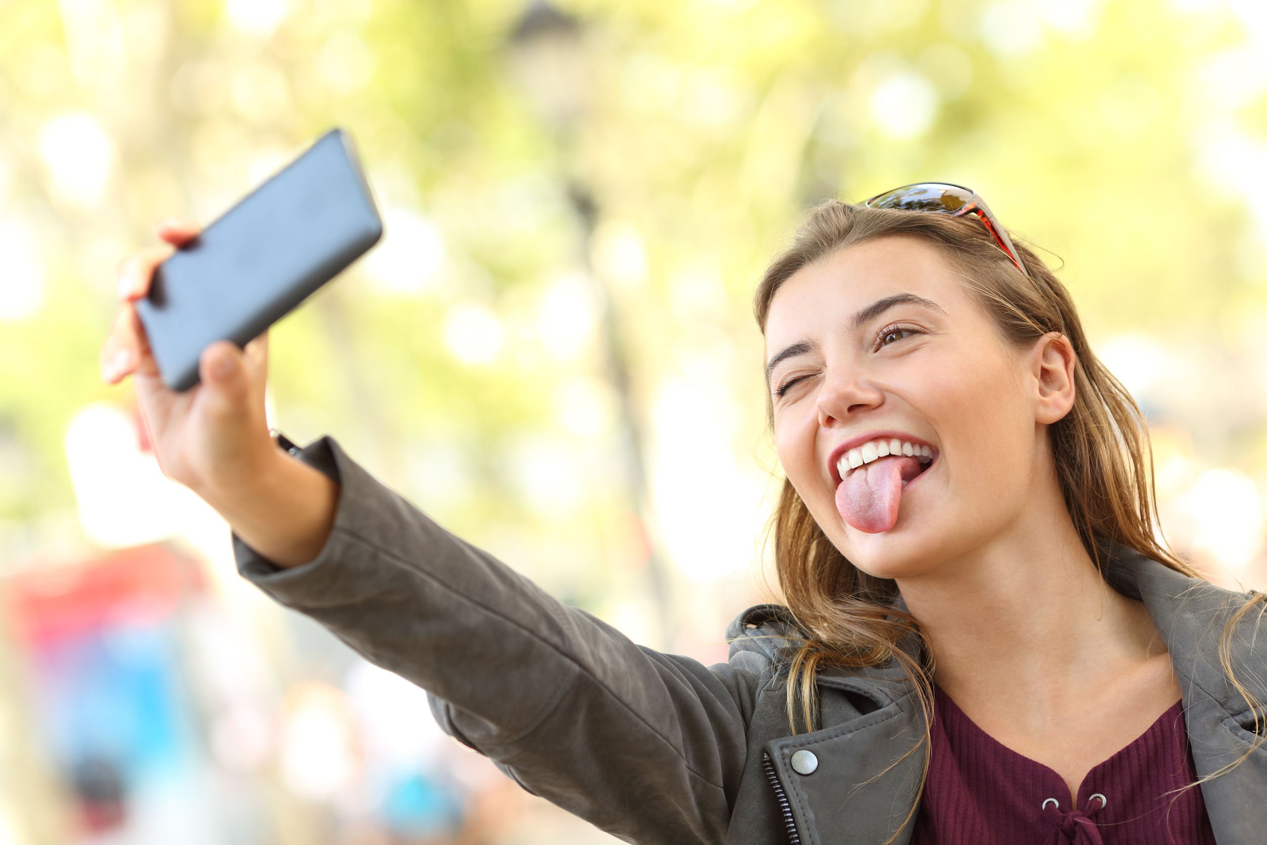 Mulher tirando selfie com a língua para fora