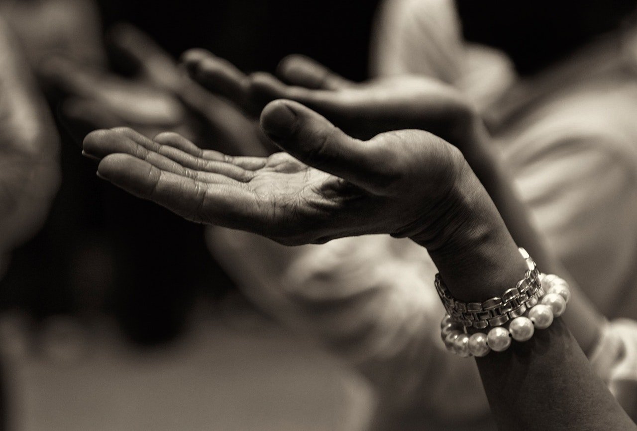 Mãos estendidas em sinal de oração.