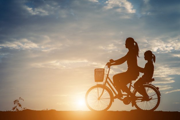 Silhueta de mulher e garota em uma bicicleta.