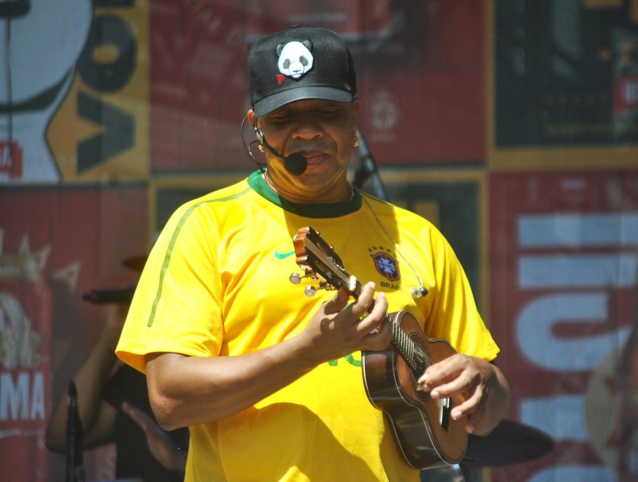 Vocalista do grupo de pagode Molejo, Anderson, tocando cavaquinho em apresentação ao vivo.