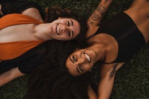 Mulheres deitadas sorrindo no gramado