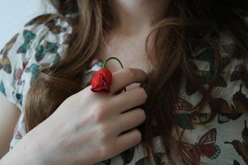 Mulher segurando rosa murcha