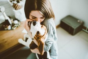 Mulher abraçando cachorro