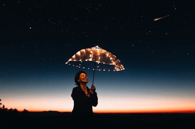 Mulher feliz segurando um guarda-chuva