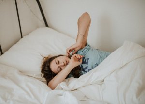 Garota se espreguiçando na cama
