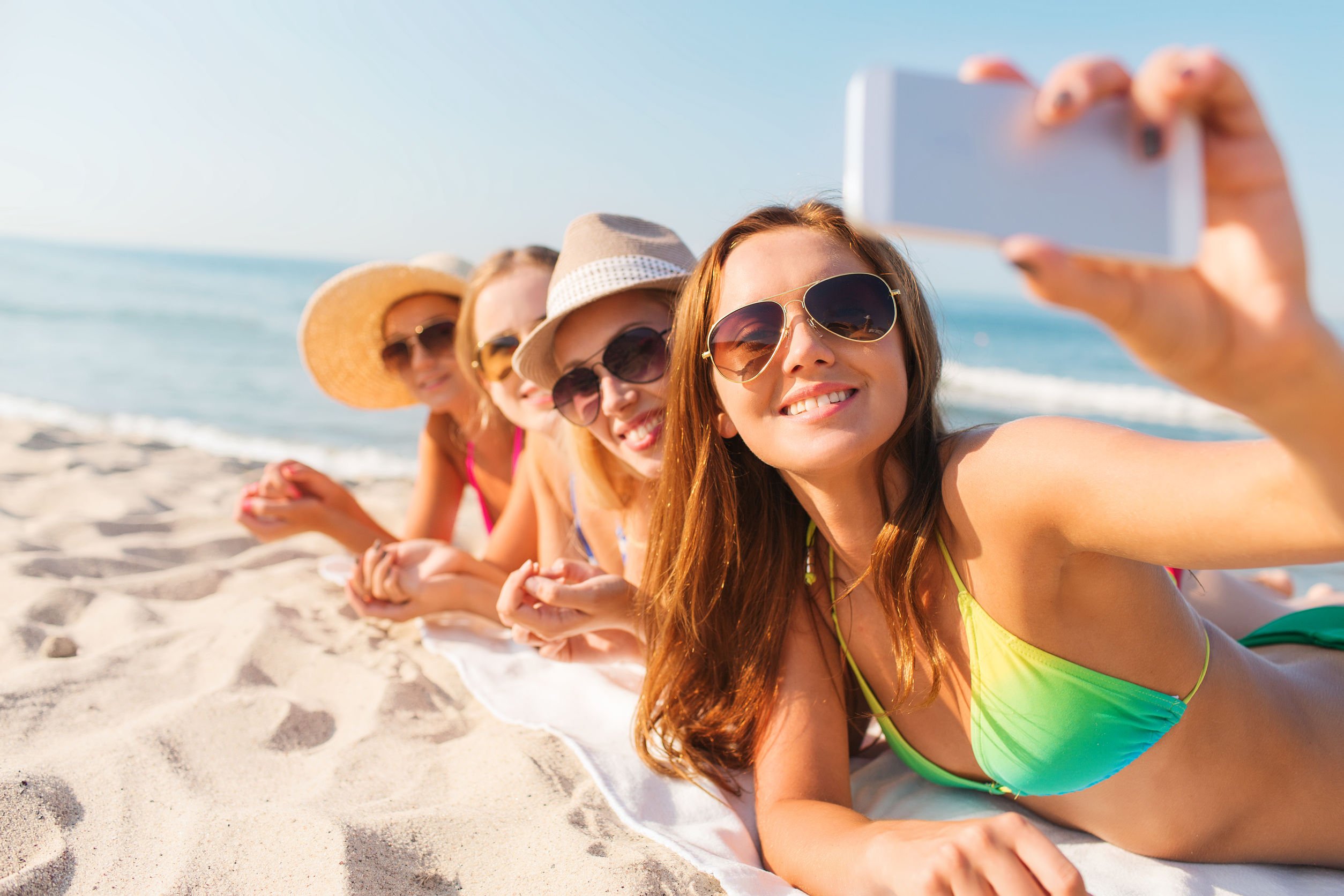 Imagem de mulheres tirando selfie na praia